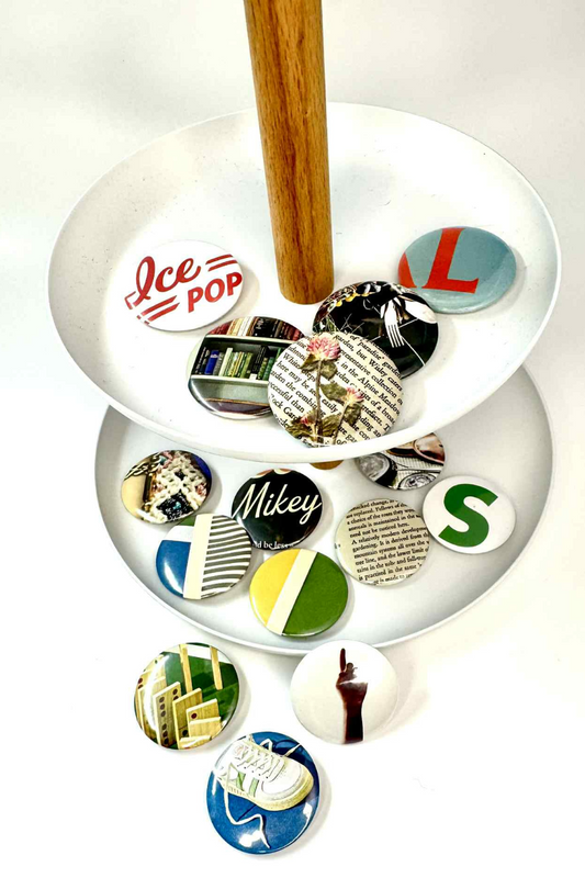 Collection of colorful buttons on a white stand with a wooden base.